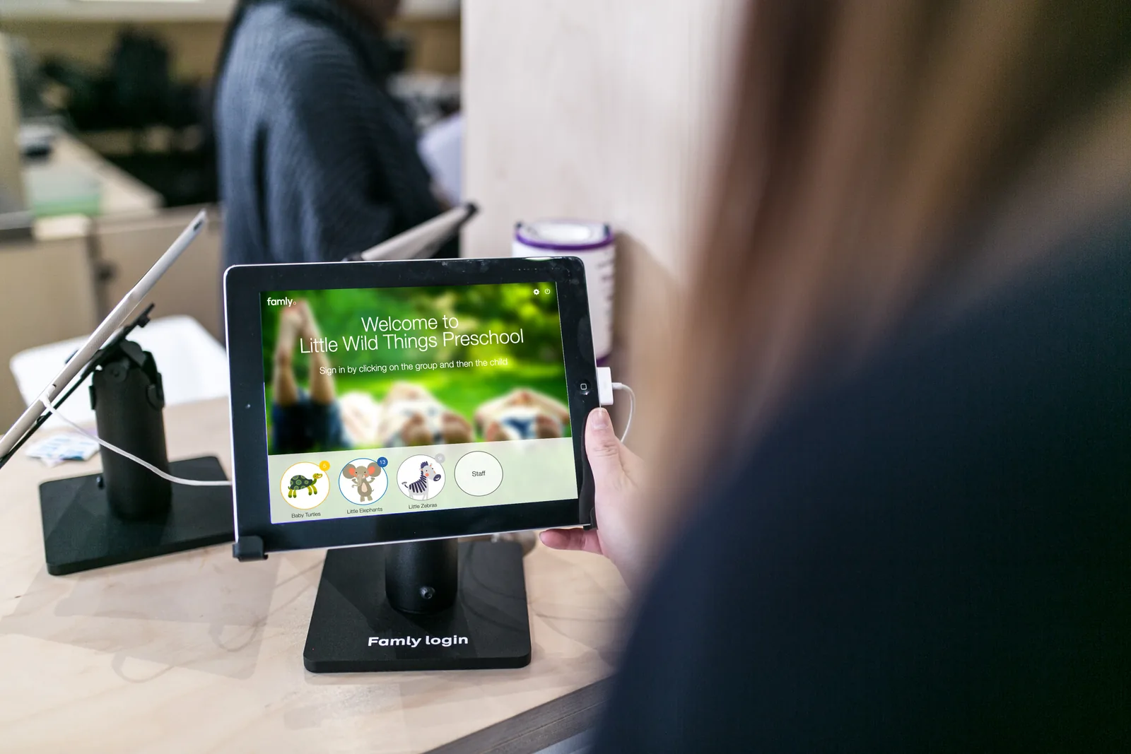 The Famly app on a tablet at a preschool sign-in desk