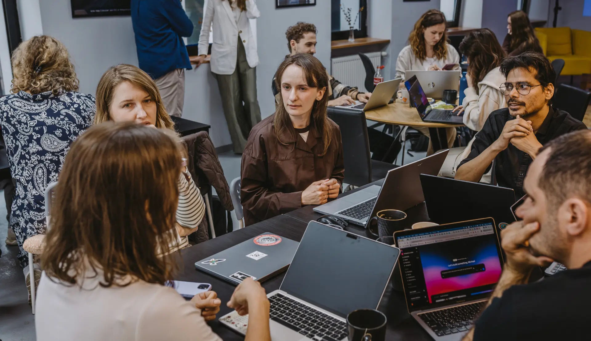 A team of four in discussion around laptops at a Product Build Day